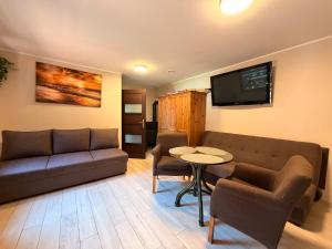 a living room with a couch and a table at Zefir Domek nr 5 in Dąbki