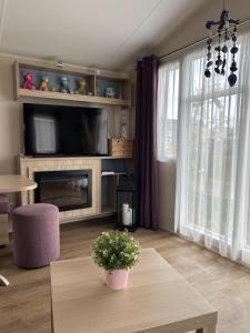 a living room with a tv and a table at ZeeGlück in Oostkapelle +4 photos