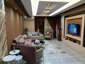 a living room with couches and a flat screen tv at عمارة 14 in Madīnat ash Shurūq