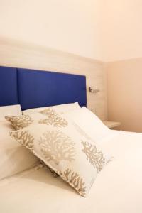 a bedroom with a white bed with a blue headboard at Sanremo Apartments - A Due Passi in Sanremo
