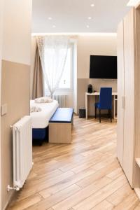 a bedroom with a bed and a desk and a tv at Sanremo Apartments - A Due Passi in Sanremo