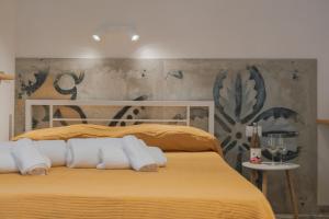 a bedroom with a yellow bed with white towels at Casa Ritunno Rooms in Favignana