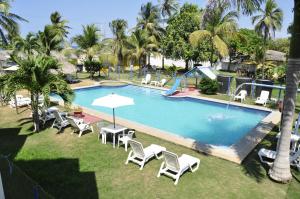 an overhead view of a swimming pool with chairs and umbrellas at Hotel Nitana in Coveñas