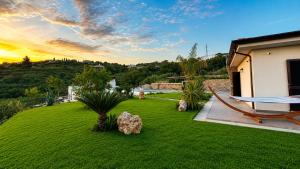 a green yard with a hammock and a house at Villa Heaven Sperlonga in Itri