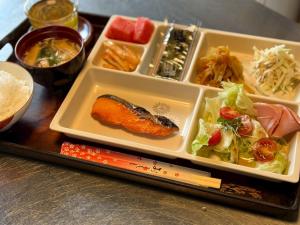 a tray of food with sushi and vegetables on a table at Villa resort -悠- in Miyakojima