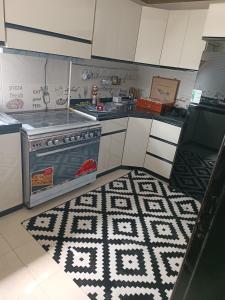 a kitchen with a stove and a rug on the floor at عمارة 14 in Madīnat ash Shurūq