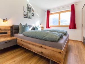 a bedroom with a wooden bed with red curtains at Appart Zell in Zellberg