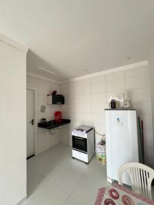 a small kitchen with a refrigerator and a stove at Kitnet em Santo Antônio in Mata de Sao Joao +5 photos