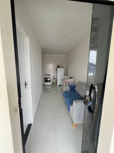 a living room with a couch and a kitchen at Kitnet em Santo Antônio in Mata de Sao Joao