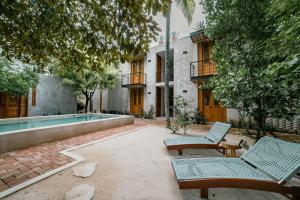 a courtyard with two chairs and a swimming pool at Hotel Boutique Alma Peregrina in Valladolid