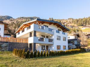 a white house with a wooden roof at Appart Zell in Zellberg