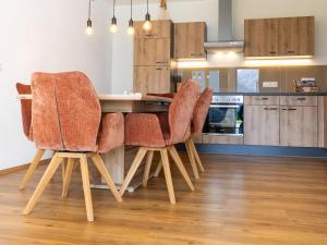a kitchen with four chairs at a counter at Appart Zell in Zellberg