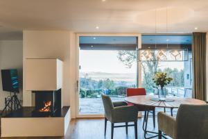 a dining room with a fireplace and a table and chairs at PanoramaLodge Samerberg in Samerberg