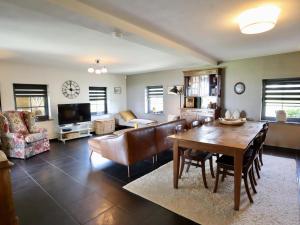 a living room with a table and a couch at Petit Wilogne in Houffalize