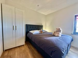 a bedroom with a bed with two stuffed animals on it at Petit Wilogne in Houffalize