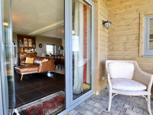 a glass door leading into a living room with a chair at Petit Wilogne in Houffalize