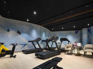 a gym with treadmills and exercise equipment in a room at Movenpick by Accor Qingdao Sunmei in Qingdao