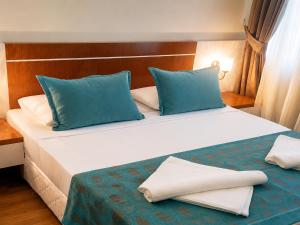 a bedroom with a large bed with blue and white pillows at Esperanza Hotel in Antalya
