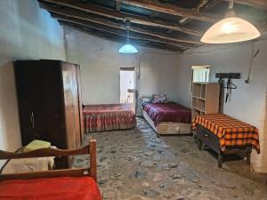 a room with two beds and a table in it at Hostal Rústico Las Pircas in Alcoguaz