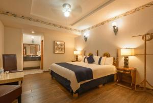 a hotel room with a bed and a television at Hotel Boutique Grand Mayes in Pátzcuaro +10 photos