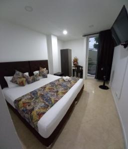 a bedroom with a large bed and a television at Raí home in Medellín