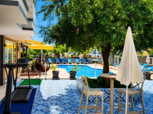 a pool with two chairs and a table and umbrella at Esperanza Hotel in Antalya +29 photos