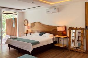 a bedroom with a large bed and two lamps at Casa Siwa in Cahuita +20 photos