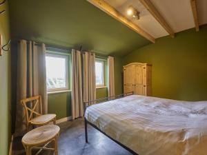 a green bedroom with a bed and two chairs at Sientjeshof 1 in Diessen