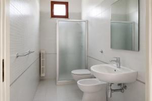 a white bathroom with a toilet and a sink at Malù camera tripla in appartamento - lungomare Crotone in Crotone +4 photos
