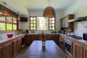 a kitchen with a table with a vase of flowers on it at Casa Siwa in Cahuita