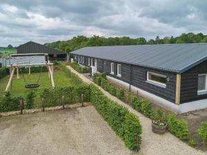 a black house with a playground and a swing at Sientjeshof 2 in Diessen