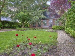 a yard with red roses in front of a house at De Binnenhof in Vriezenveen