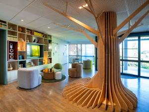 a living room with a large tree in the middle of the room at ibis Styles Guéret in Guéret