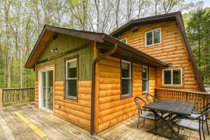 a cabin with a picnic table on a deck at Woodsy Way Cabin in Oakland