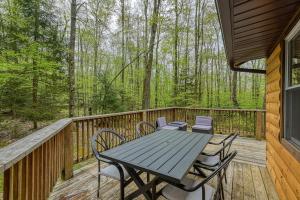 a wooden deck with a table and chairs on it at Woodsy Way Cabin in Oakland