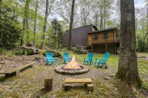a group of chairs around a fire in front of a cabin at Woodsy Way Cabin in Oakland
