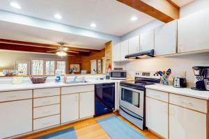 a large kitchen with white cabinets and appliances at Hibernation Hideaway in McHenry +22 photos