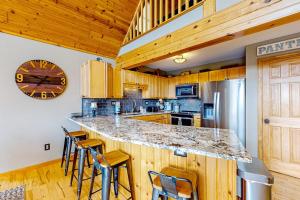 a kitchen with a large counter with chairs and a clock at Bear's Eye View in McHenry +30 photos