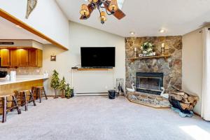 a living room with a stone fireplace and a television at Oakland Oasis in Oakland