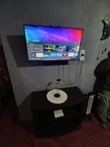 a flat screen tv on a wall with a table at Hospedaje Tidae in Tinogasta