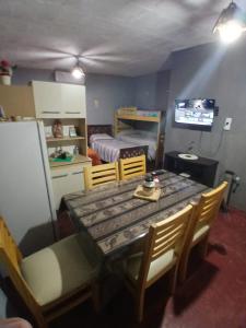 a dining room with a table and chairs and a bedroom at Hospedaje Tidae in Tinogasta