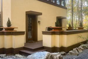 a house with two potted plants on the side of it at The Frank Lloyd Wright Home @ Deep Creek, MD in Bittinger