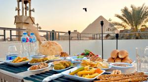 a table with many plates of food on it at Villa Golden Sunset Pyramids in Cairo