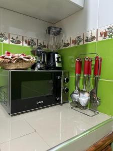 a kitchen with a counter with a microwave and utensils at Jannat Résidence in Ouarzazate