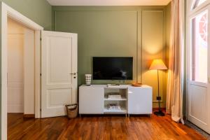 a living room with a tv and a white cabinet at Villa dei Ricordi - Apartments near Como, Milan and Malpensa in Mozzate