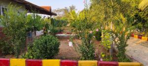 a garden with trees and plants in front of a house at Surya farms in Rajiv Gandhi International Airport