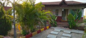 a house with palm trees in front of it at Surya farms in Rajiv Gandhi International Airport