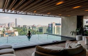 a woman in a swimming pool in a building at University Tower by Kukun Apartments in Mexico City