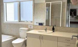 a bathroom with a sink and a toilet and a mirror at The River House in Merrijig +20 photos