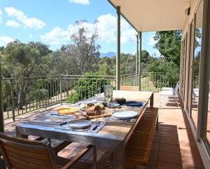 a dining table on a deck with a view at The River House in Merrijig